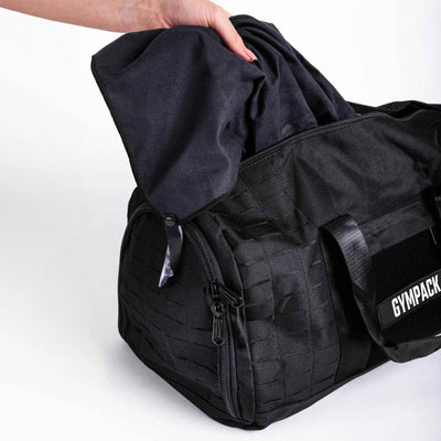 Bolsa Gympack Duffel 40L Preta - Vista Lateral com Modelo Inserindo Item